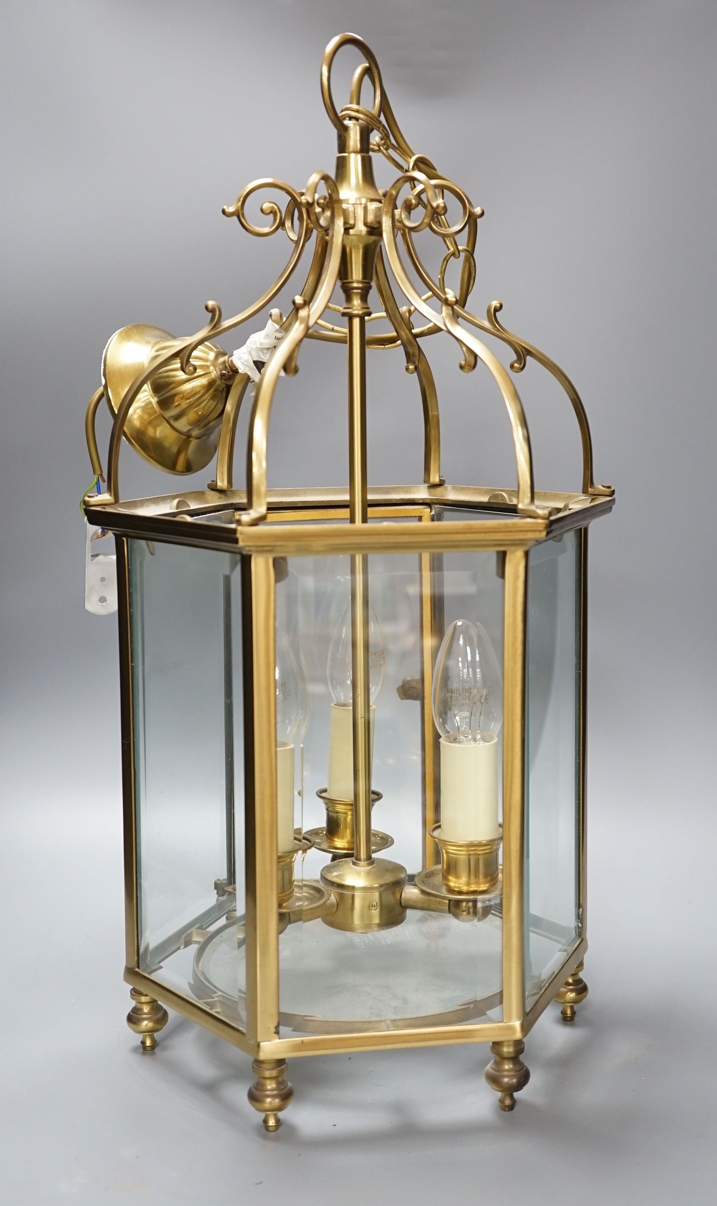 A three light brass hall lantern in hexagonal glass opening case - 56cm high excluding ceiling rose suspension